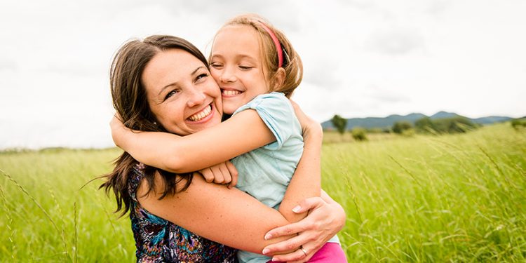 Mother and child are hugging and having fun outdoor in nature