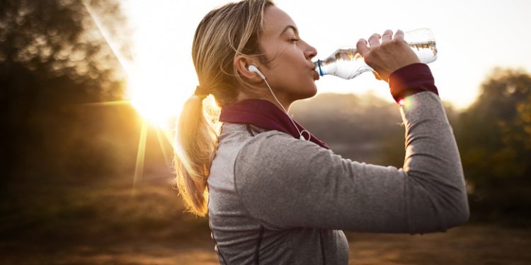 Young fit woman taking a break from jogging in the nature